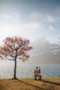 情侣坐在湖边，以山为背景，享受大自然的宁静