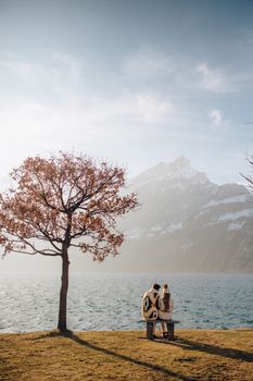 情侣坐在湖边，以山为背景，享受大自然的宁静