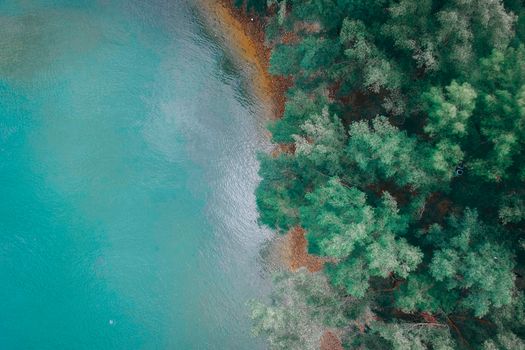 Breathtaking drone view of turquoise ocean with sandy beach surrounded by green lush vegetation in daytime