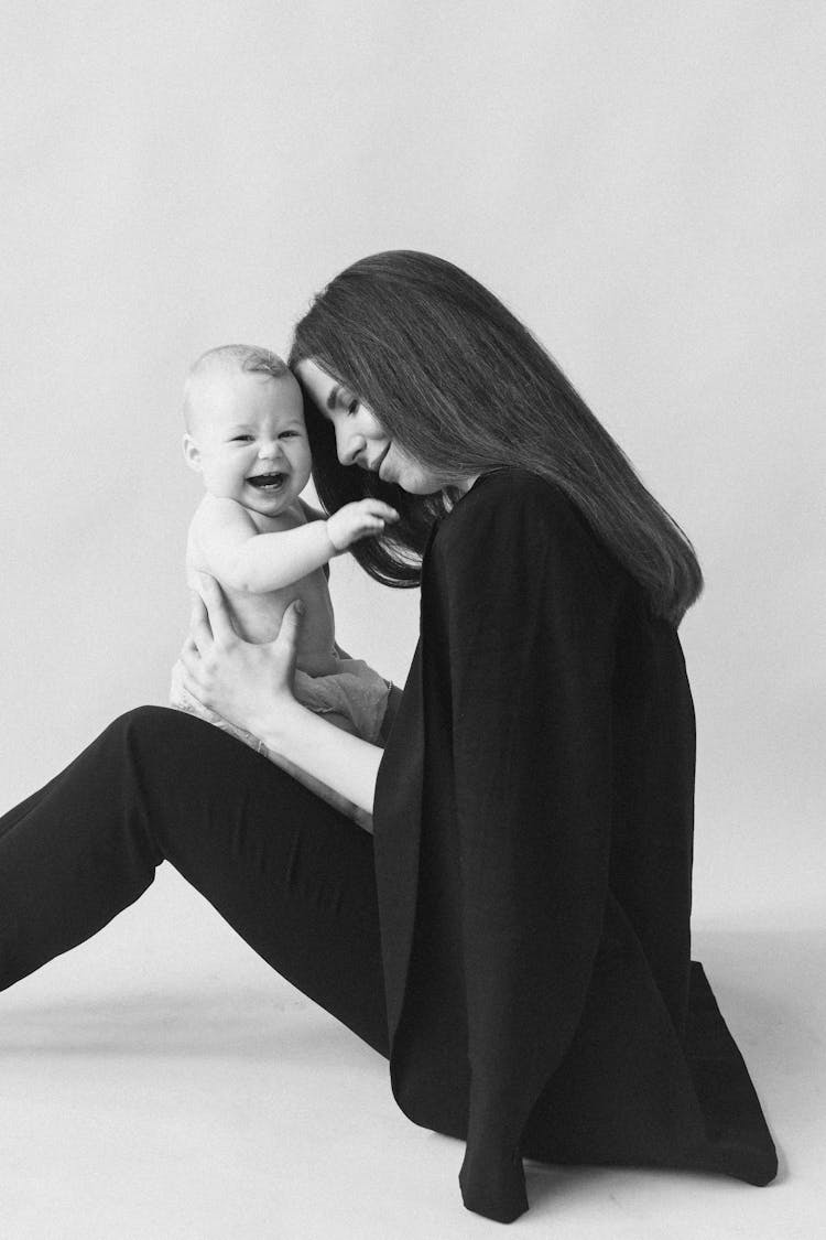 Grayscale Photo Of Woman Carrying Her Child