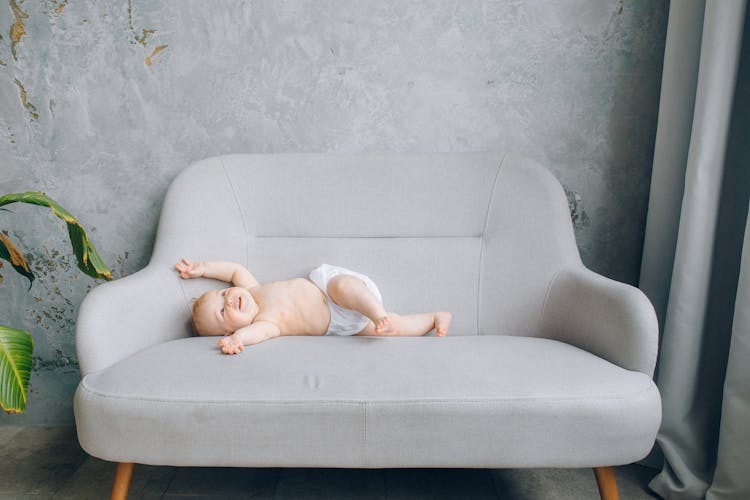 A Baby Boy Lying On The Sofa 