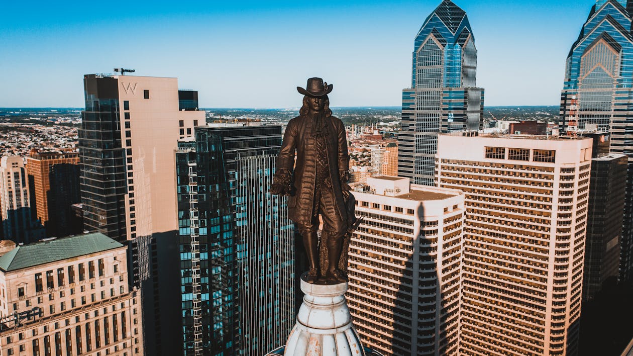 Bronze statue of founder of city on top of building · Free Stock Photo