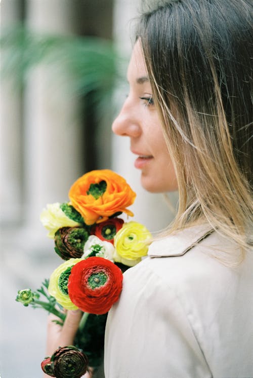Side Profile of a Woman Holding Blooming Flowers