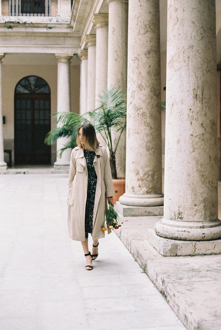 Woman In Beige Coat Walking On A Hallway