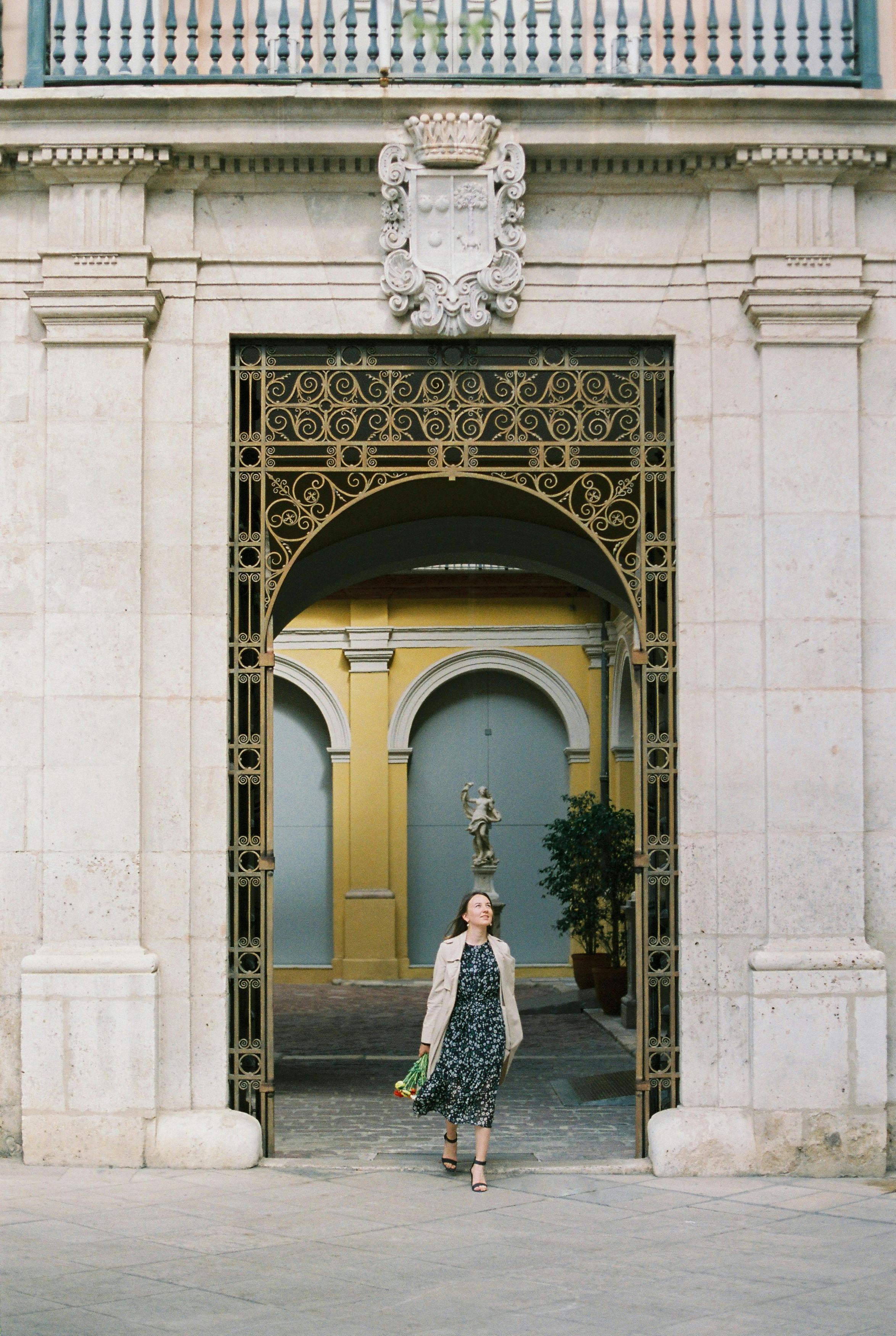 woman in white dress standing in front of white concrete building