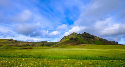 Kostnadsfri bild av åkermark, berg, blå himmel