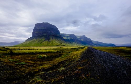 Free Stunning view of a rugged mountain in a lush highland setting under a moody sky. Stock Photo