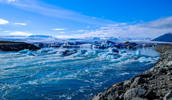 探索这片令人惊叹的冰川景观，这里有冰山、明亮的天空，以及流经冰雪地形的宁静河流