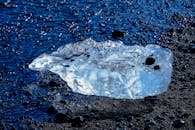 在岩石海岸上，闪闪发光的冰山展示了大自然的冰冷之美