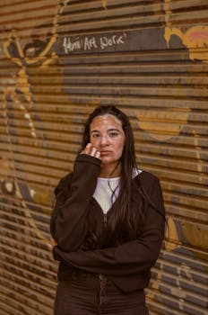A woman standing against a graffiti-covered wall in Cairo, expressing urban street style.