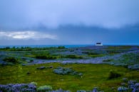 在多云的天空下，美丽的薰衣草田野以乡村房屋和山脉为背景