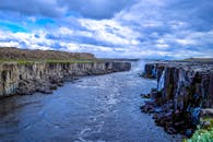 在壮丽的天空下，冰岛崎岖的峡谷、河流和瀑布展现出壮丽景色
