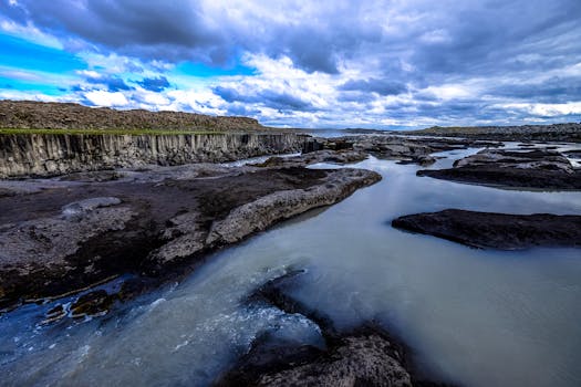 在充满戏剧性的云层天空下，一条岩石河流流淌，景色令人惊叹