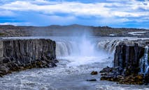 蓝天之下，壮观的瀑布从岩石峡谷中倾泻而下，形成雄伟的自然景观