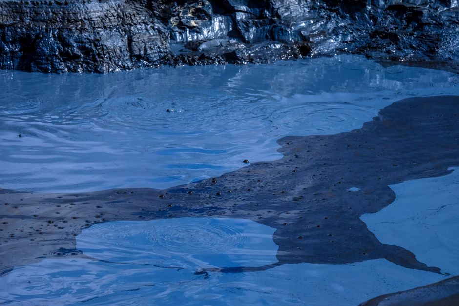 Close-up view of tranquil blue water with ripples and rocky edges, perfect for nature and abstract themes.
