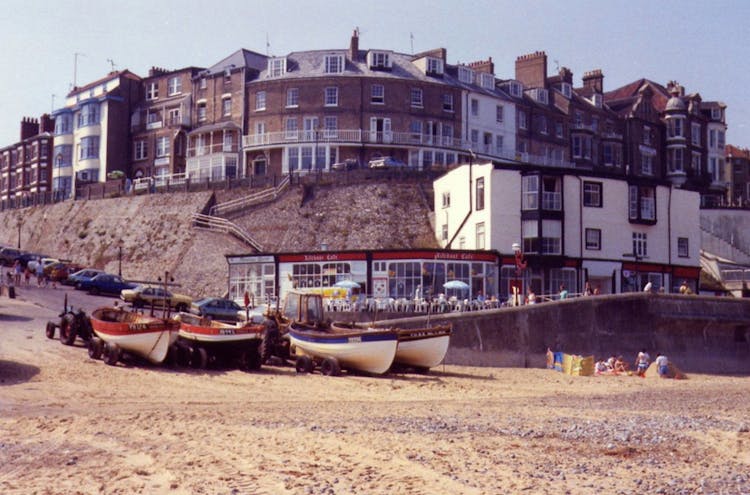 Building On A Hill With Motor Boats Near The Shore