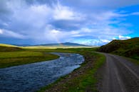 宁静的乡村风景中，蜿蜒的河流、连绵起伏的山丘和彩虹构成了一幅宁静的画面