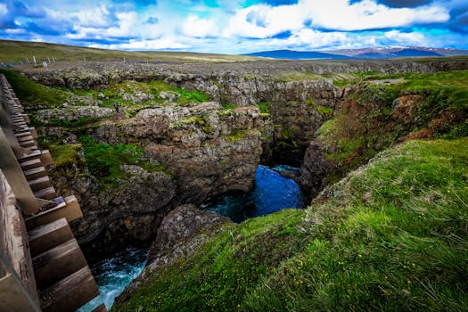 在部分多云的天空下，这个峡谷令人印象深刻，急流环绕着岩石悬崖和郁郁葱葱的绿色植物