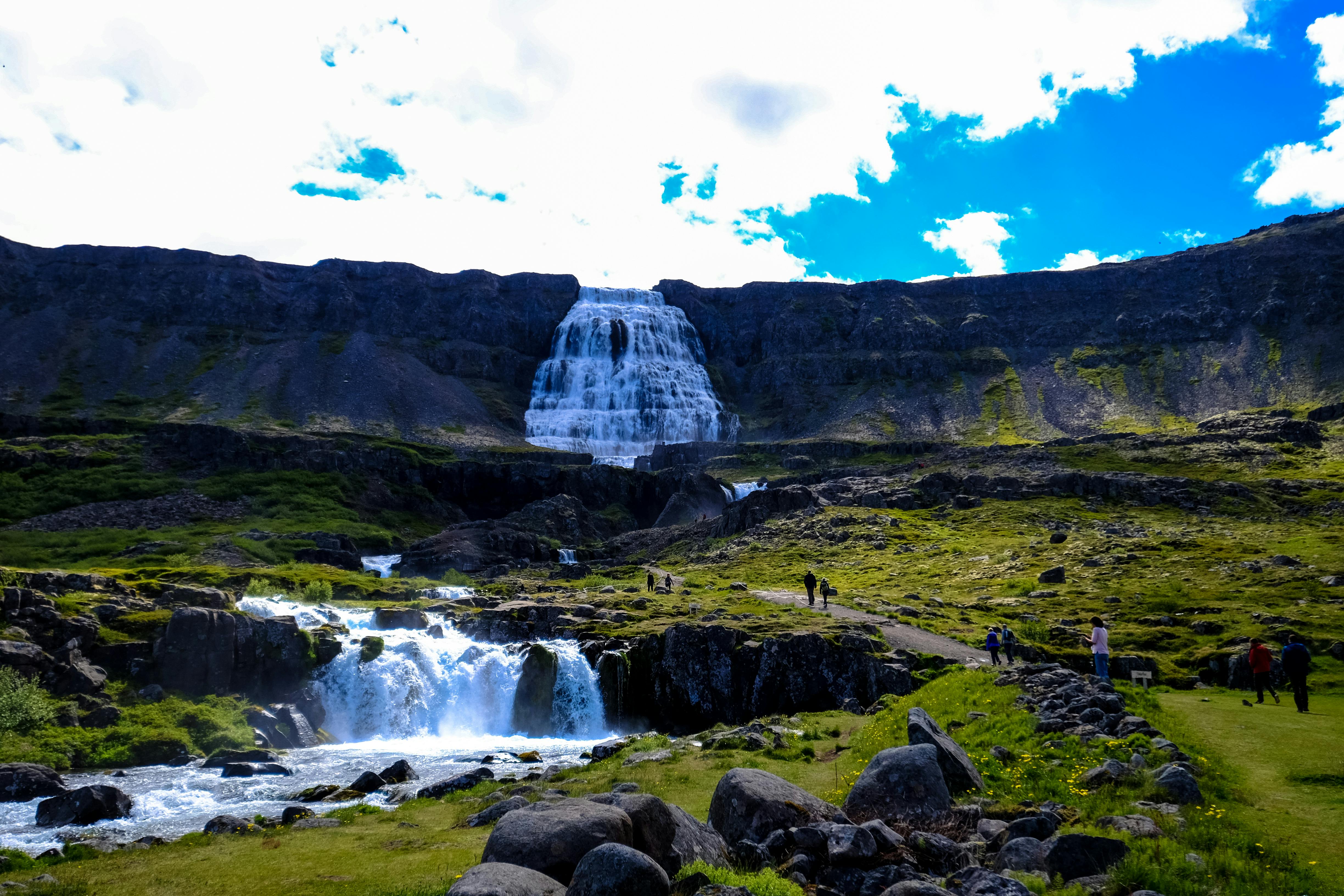 person walking near waterfall
