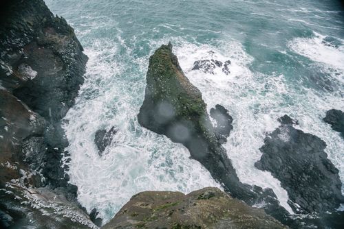 Free Powerful waves crash against rugged cliffs, showcasing nature's raw beauty and energy from above. Stock Photo