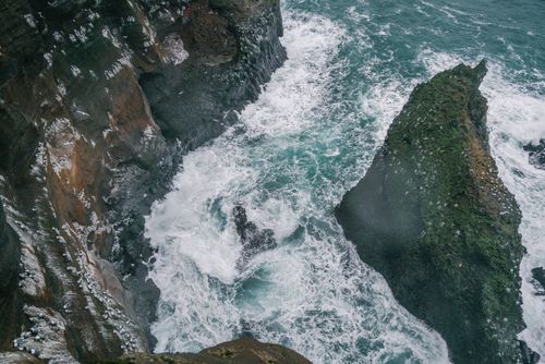 Free A breathtaking view of rugged cliffs and powerful ocean waves, showcasing nature's raw beauty. Stock Photo