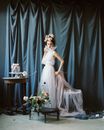 Woman in White Sleeveless Dress Standing Beside Table With Flowers