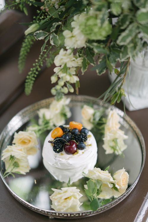 Free Beautifully decorated cake with fresh berries and flowers on a metallic tray, captured in a still life setting. Stock Photo