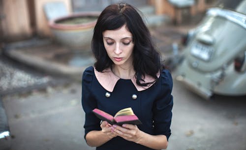 A Woman in Blue Top Holding a Book