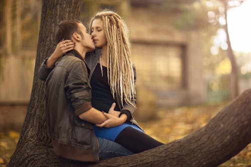 A Couple Sitting on a Tree Kissing