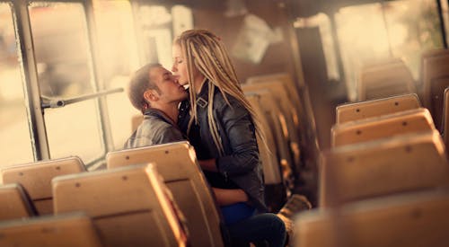 A Woman Sitting on a Man Inside a Bus