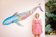 A Woman Standing Beside a Wall with Whale Painting