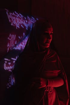 一个戴头巾的女人，投影着红色的阿拉伯书法
