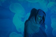一个女人的创意肖像，头巾与水母投影照亮了她
