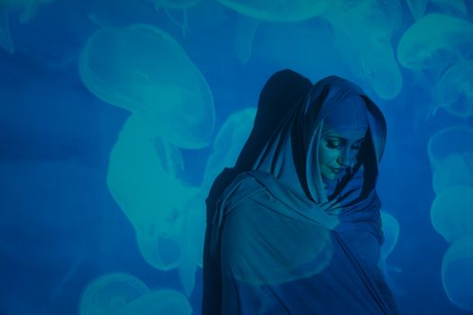 一个女人的创意肖像，头巾与水母投影照亮了她