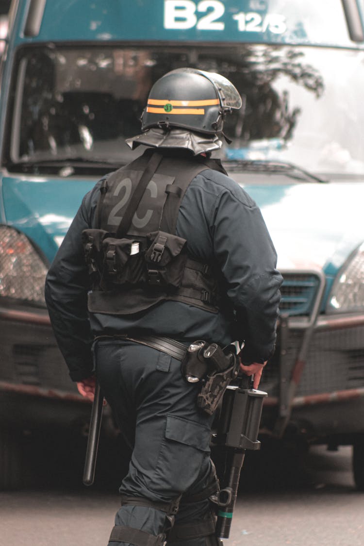 Police Officer In Helmet And Protective Vest