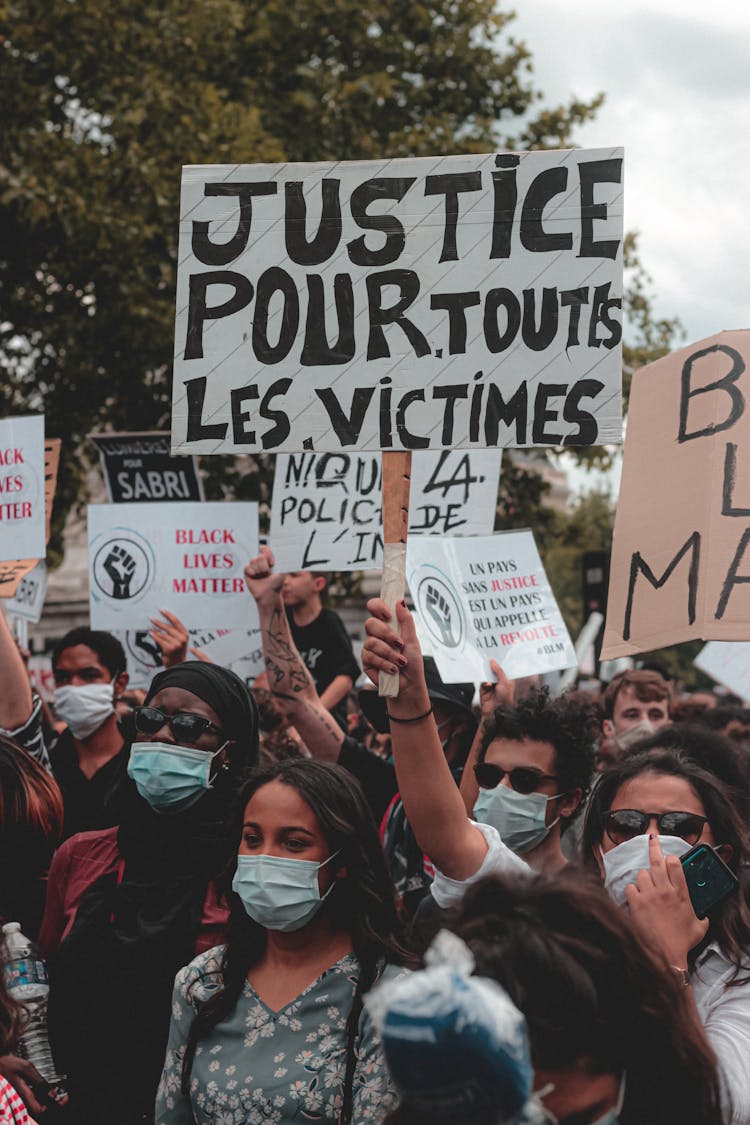 Protesting People In Masks Standing On Street