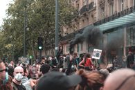Anonymous ethnic crowd of people standing on city street with posters and smoke bomb in protest against racism