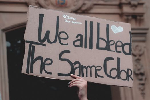 Hand holding cardboard sign at protest