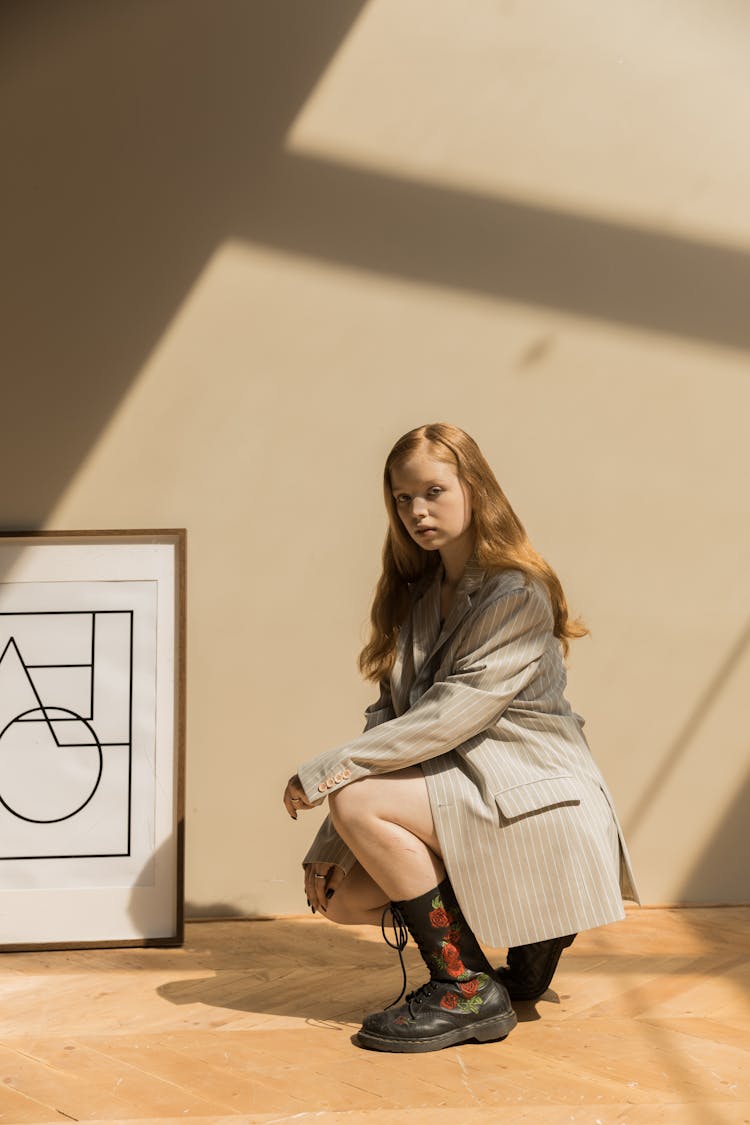 A Woman In Gray Blazer Sitting Near A Picture Frame