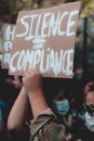 Unrecognizable person with poster of protect people