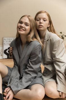 两个女人穿着西装，在室内分享一个休闲友好的时刻