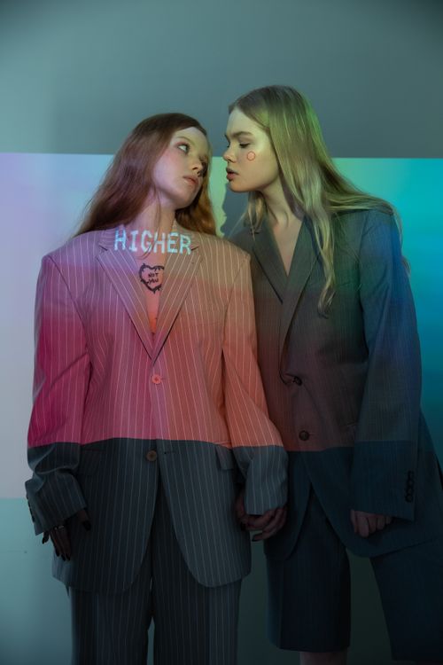 Free A creative, colorful portrait of two women in suits with a projection effect on them. Stock Photo