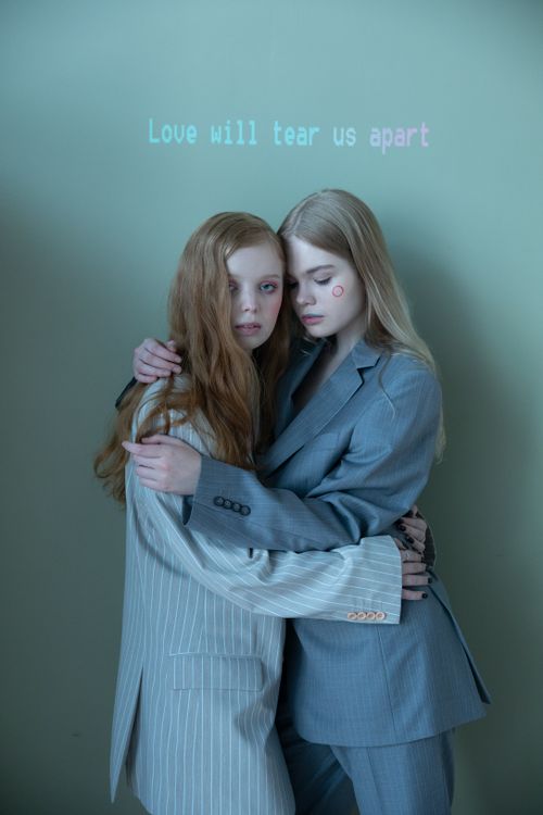 Free Two women in suits embrace in a studio setting, conveying love and connection. Stock Photo