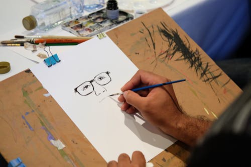 Free An Artist Doing Drawing on a White Paper Stock Photo