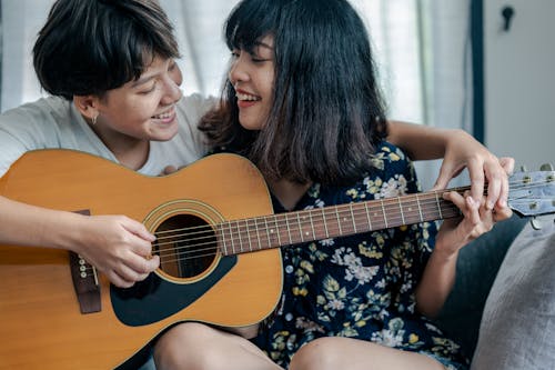 Free Man and Women Looking at Each Other While Holding a Guitar Stock Photo