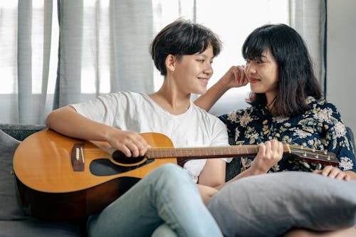 Person Holding Guitar While Looking at a Person