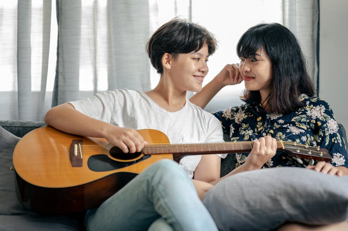 Free Person Holding Guitar While Looking at a Person Stock Photo