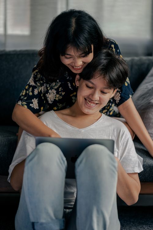 Free A cheerful couple enjoying time together indoors, sharing a moment on a laptop. Stock Photo