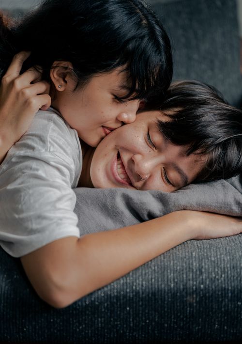 Free A close-up of an affectionate couple embracing on a couch, expressing love and intimacy. Stock Photo