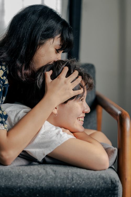Free Joyful couple sharing a tender moment on a cozy couch indoors, symbolizing love and relaxation. Stock Photo